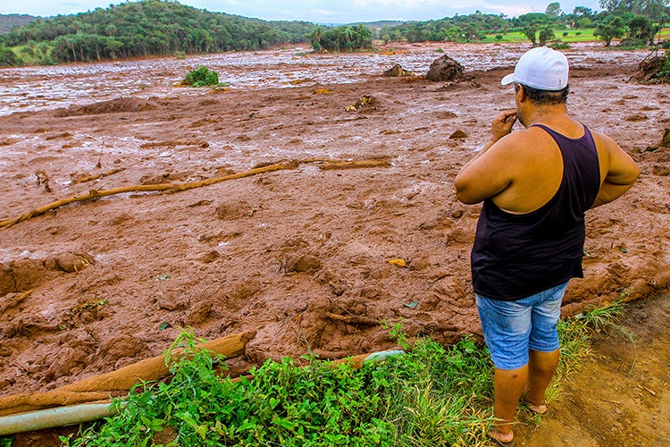 man looking over the damage from tailings at Brumadhino