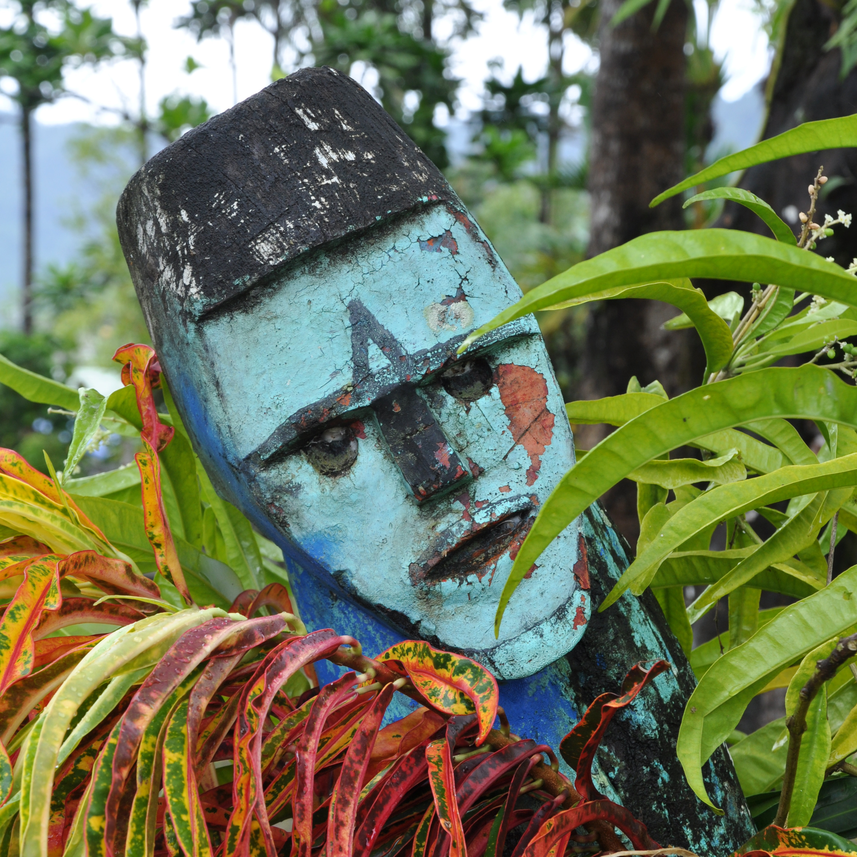 Cultural mask displayed among foliage 