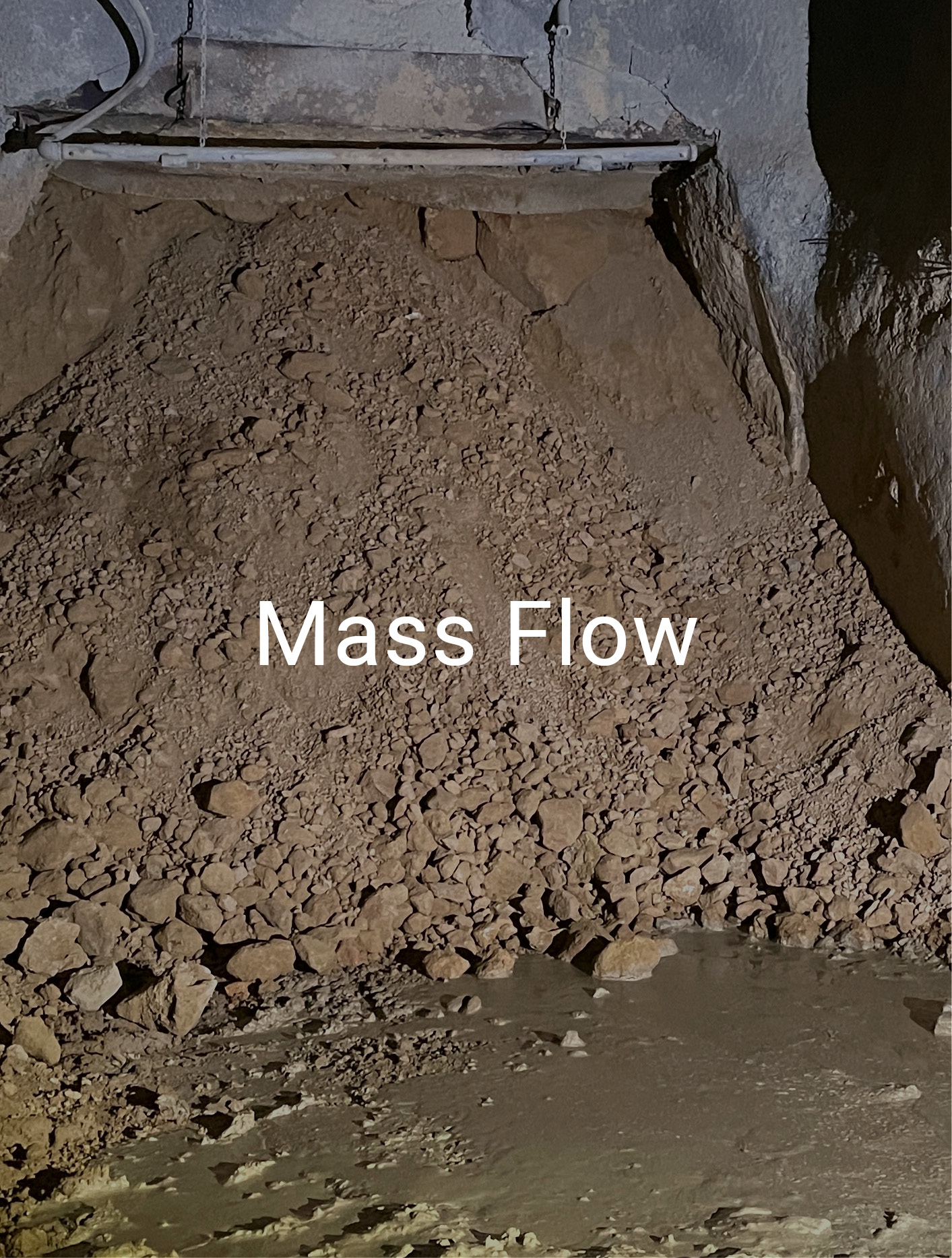 text 'Mass Flow' over background of mound of dirt and minerals