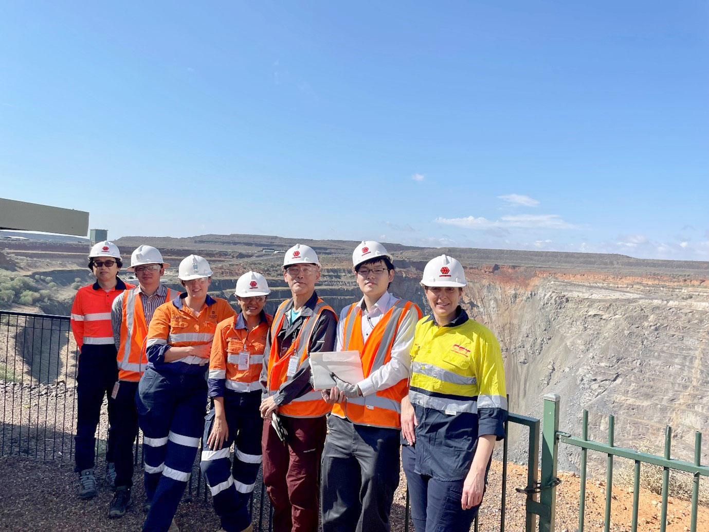 Team from JOGMEC, Anita Parbhakar-Fox, Helen Degeling and Laura Jackson group photo with a mine site behind them