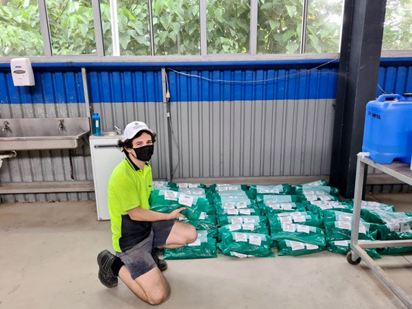 Joshua Crow kneeling next to samples