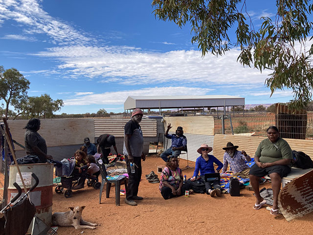 Sarah Holcombe visits Herman Whiskey and the Multa family at Haasts Bluff, with Kathleen Dixon to her right.