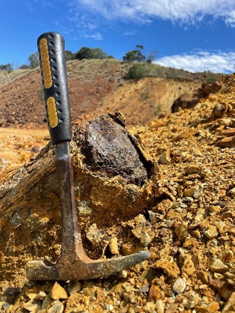 Hammer leaning against a sulphidic boulder