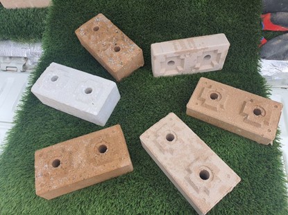 Different types if example bricks, produced by Mobile Crisis Construction, showcased at the Paydirt 2023 Battery Minerals conference