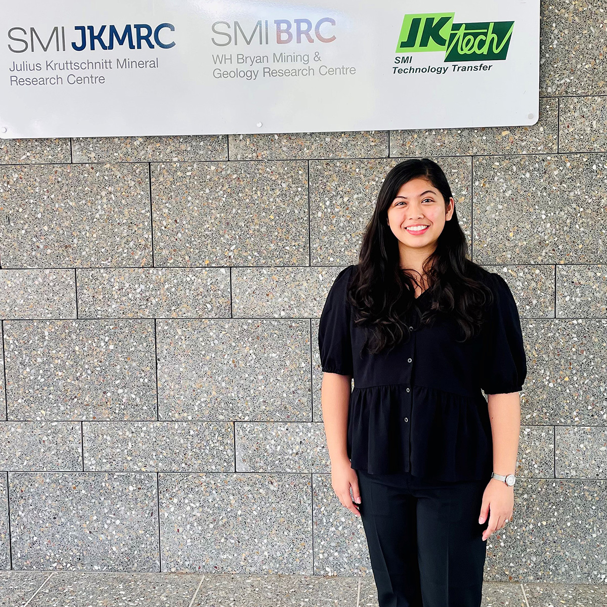 Princess Gan at the UQ Experimental Mine Site campus, in front of Centre signs 