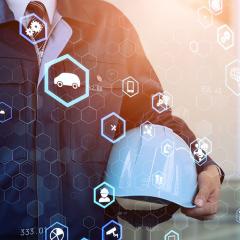 person holding a hard hat surrounded by floating holographic icons 