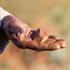 close up of First Nations person holding artefact in hand