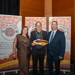 Rodger Barnes holding his award at the awards event