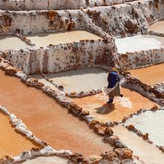 Female worker in Maras salt mines in Sacred Valley, Cusco, Peru