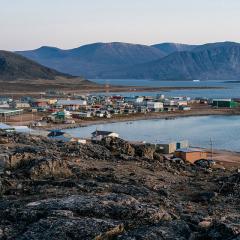 Dusk in a harsh arctic landscape with bare hills and ocean. Overlook of Inuit settlement of Qikiqtarjuaq, Broughton Island, Nunavut